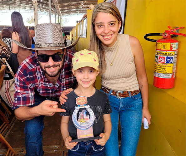 Reprodução/Arquivo Pessoal - Lara com os pais Filipe e Ana, após conquistar a Categoria Kids do Maracaí Rodeio Fest 2024 - Foto: Reprodução/Arquivo Pessoal