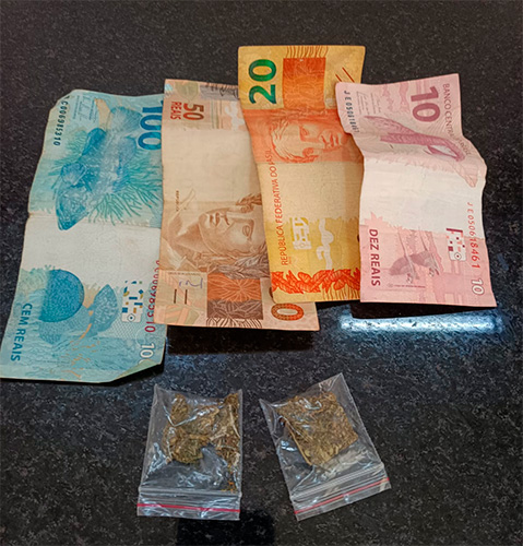 Reprodução/Polícia Militar - Na abordagem foram localizados com o indivíduo porções de maconha, um aparelho celular e R$180,00 em espécie - Foto: Reprodução/Polícia Militar